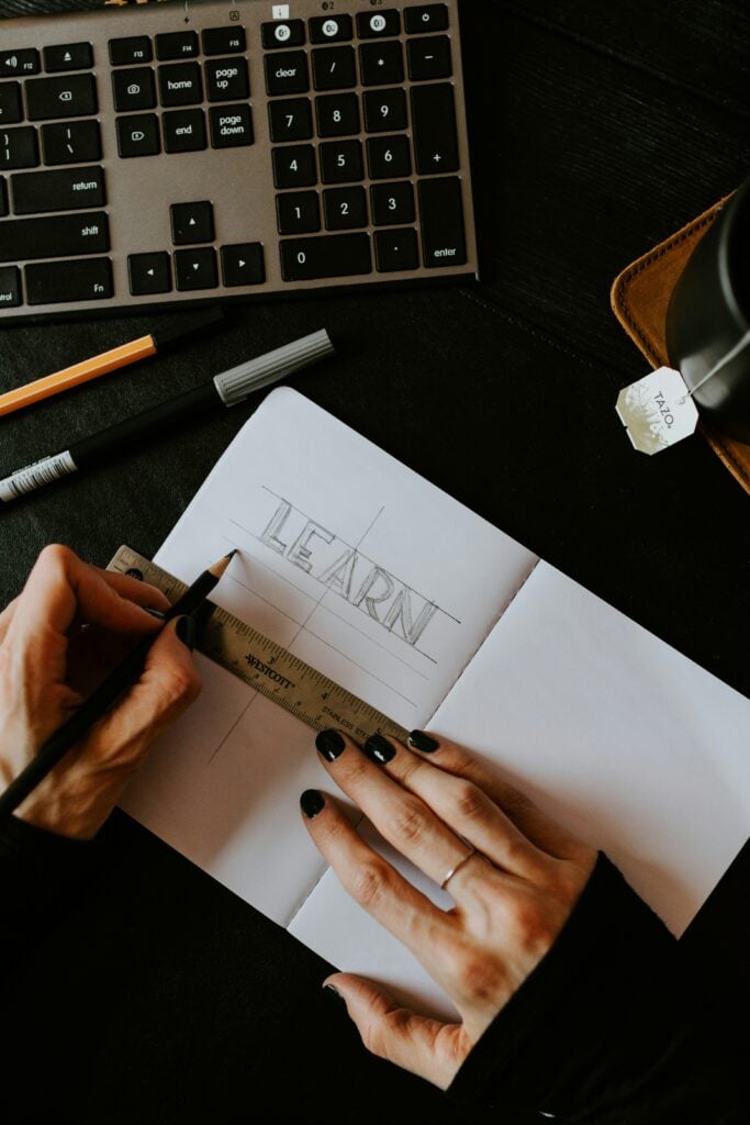 Woman’s hands writing “learn” in a notebook representing customer experience for private instruction
