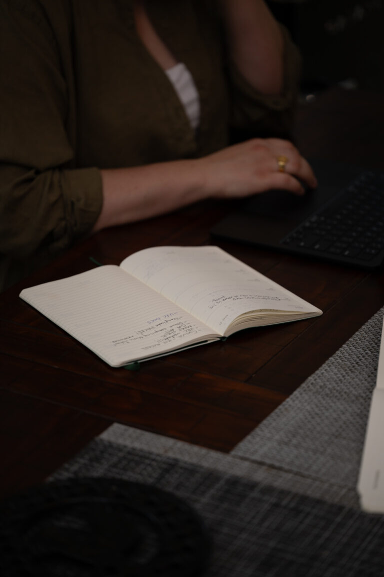 Laptop and notebook being used for small business workflow planning