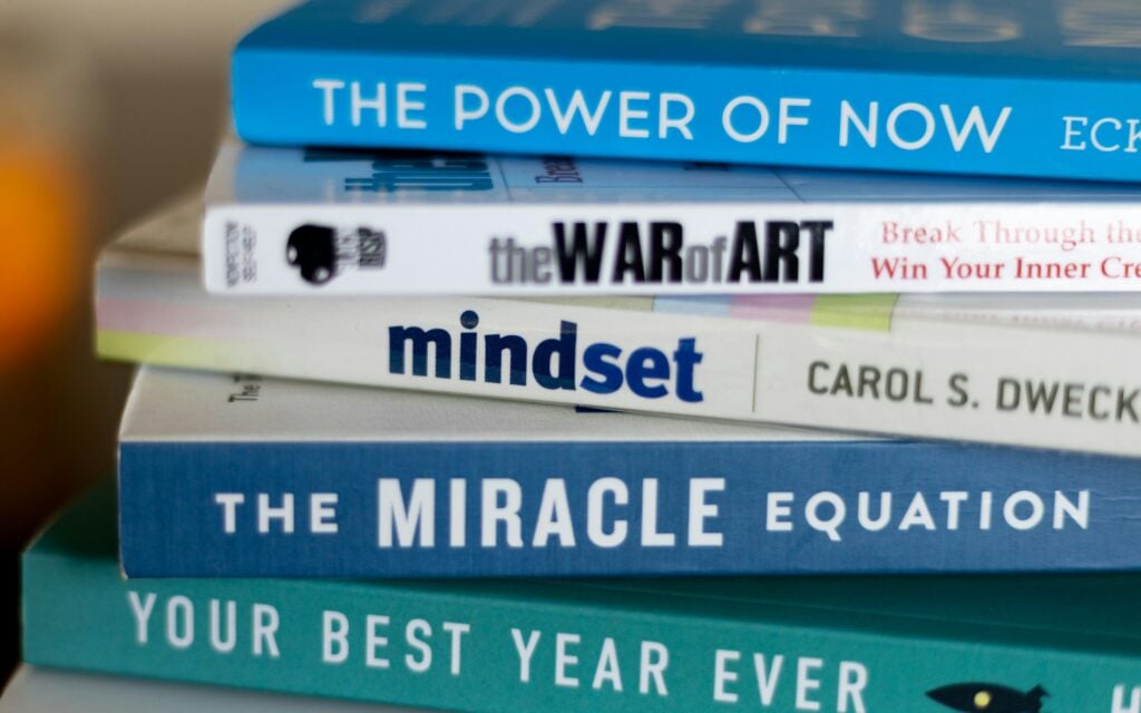 stack of mindset development books to illustrate the theme of mindset being a trap