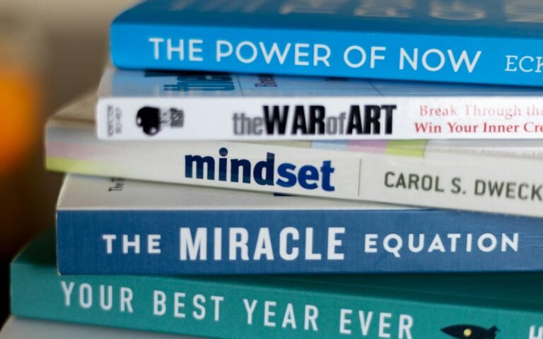 stack of mindset development books to illustrate the theme of mindset being a trap