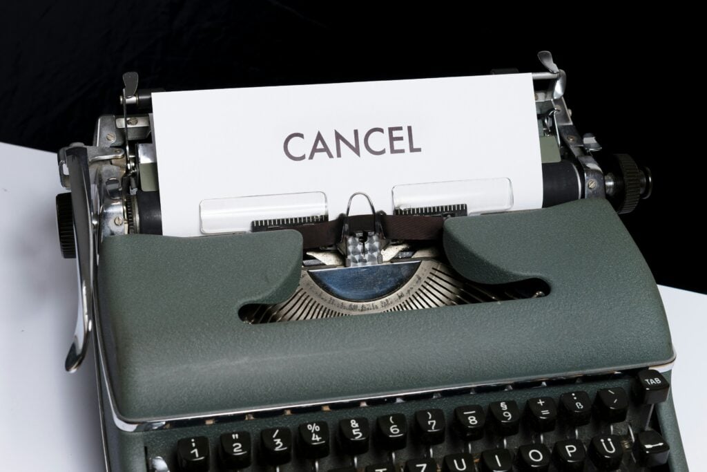 typewriter with a page showing the word 'cancel' to demonstrate subscription cancellation policies and frustration customers experience when trying to exit a service