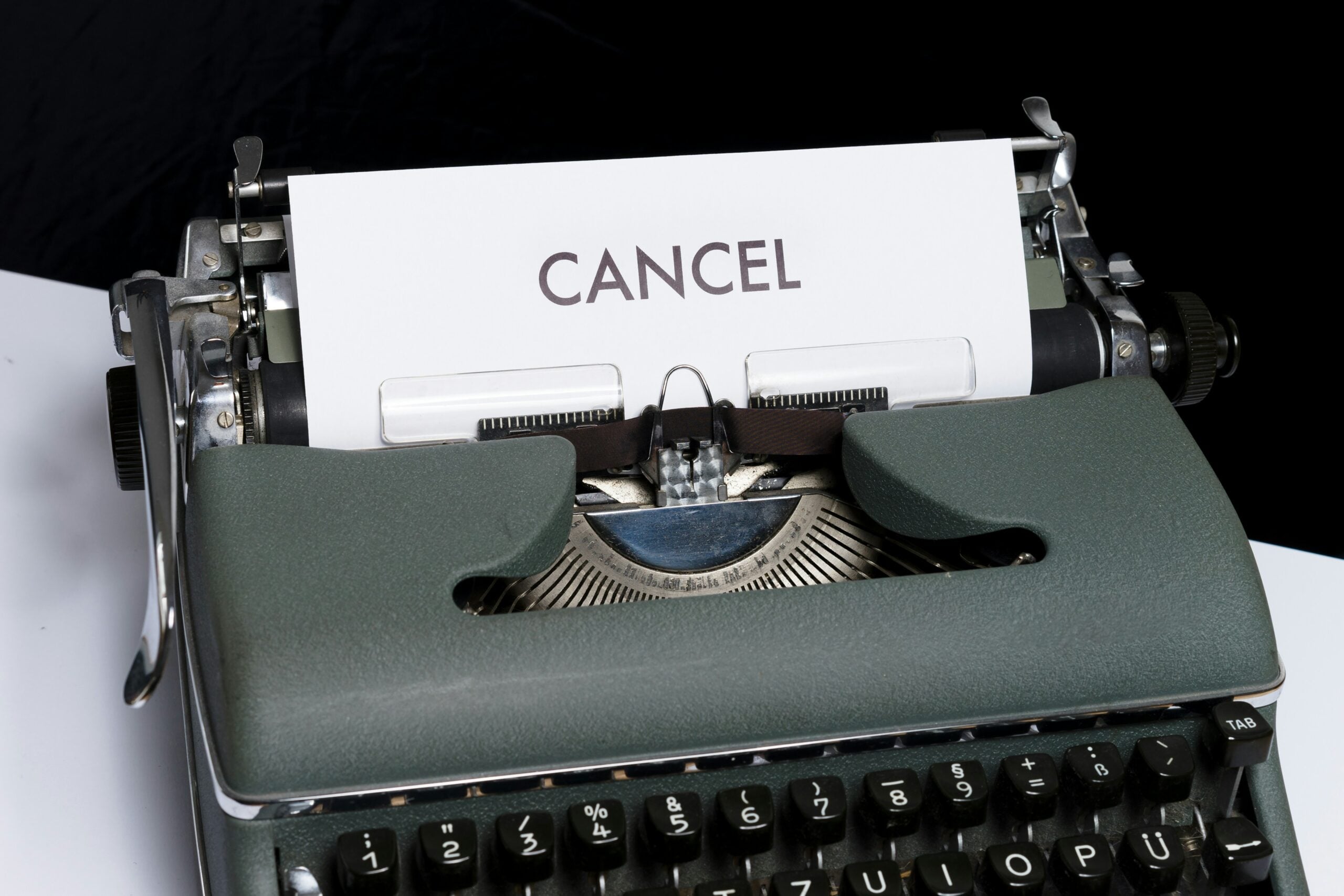 typewriter with a page showing the word 'cancel' to demonstrate subscription cancellation policies and frustration customers experience when trying to exit a service